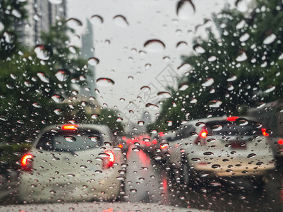 通过汽车挡风玻璃与雨滴在雨中驾驶的繁忙图片