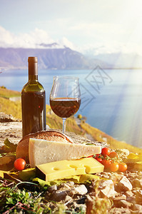 红葡萄酒奶酪面包和樱桃番茄瑞士拉沃图片