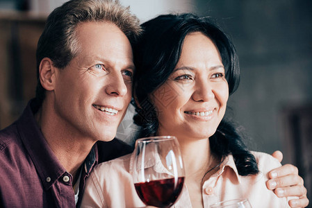 快乐的多民族夫妇喝红酒一起眺望远方图片