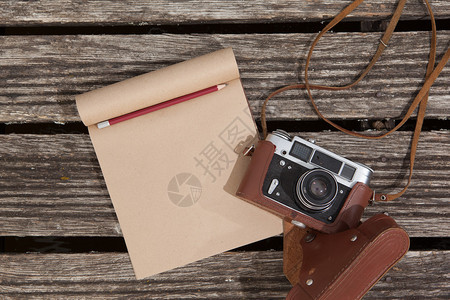 古老的胶片摄像机和一张笔记本用铅图片