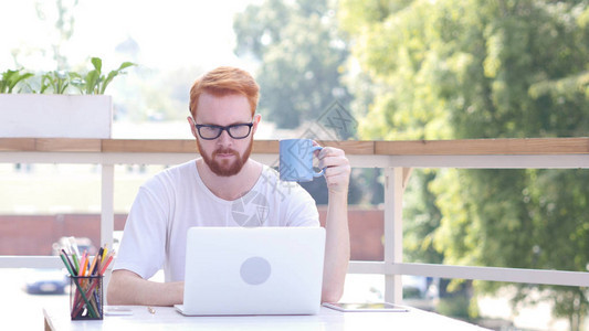 饮水咖啡在线笔记本电脑上工作坐在外门图片