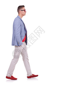 一位时尚男士在白色上向前走的侧视图图片