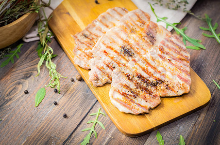 烤牛肉猪肉牛排和草药及香料放在生锈的木制桌上肉图片