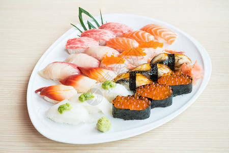 生新鲜鲑鱼虾和白盘中更多寿司图片