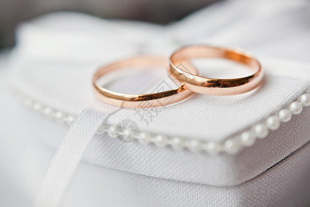 枕形上的金结婚戒指背景图片