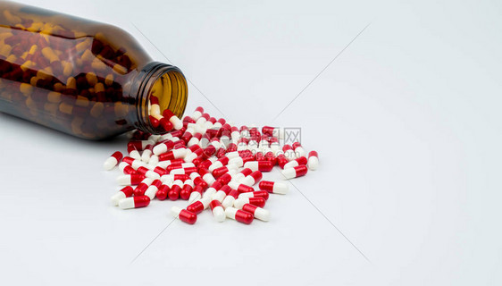 五颜六色的抗生素胶囊丸与白色背景上的琥珀色玻璃瓶耐药合理使用抗生素药物健康政策和图片