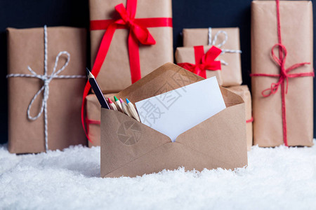 礼盒样机白雪上的圣诞礼盒和信封背景