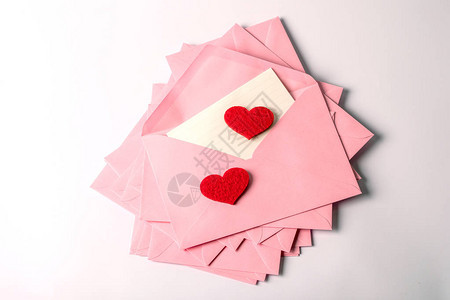 特写堆叠粉色信封和邮件信纸和红色赫拉特图片