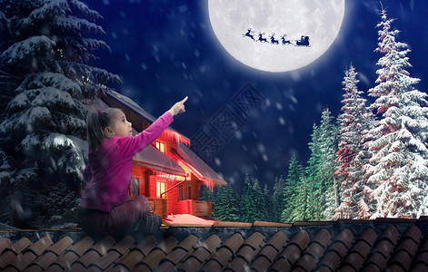 女孩坐在屋顶上在圣诞节前夕指向天空中图片