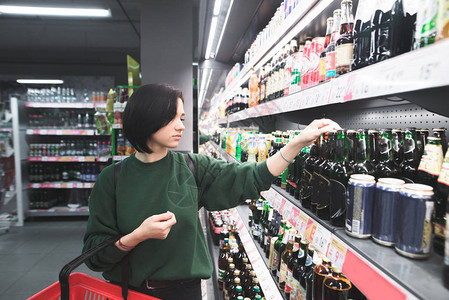 女人在超市冰柜里挑选啤酒图片