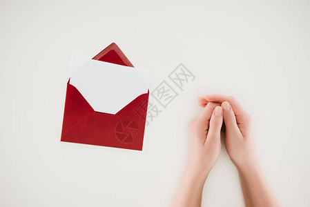 妇女手握在打开的红色信封上用白纸背景图片