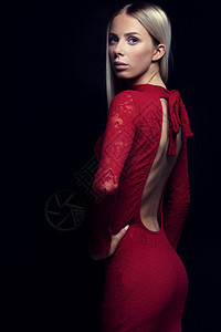 时装照片一个美丽而时尚的年轻女子金发穿着黑色背景的红礼服天然修饰图片