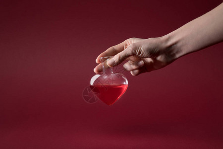 女握着心形玻璃瓶的爱灵丹酒图片