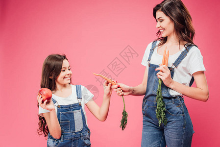 开心的妈给女儿胡萝卜孤立在图片