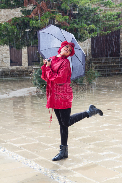 年轻美丽的caucasians女人带着雨伞穿着红衣图片