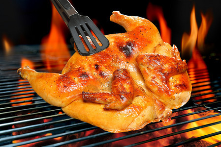 火焰状烤架上的烤鸡图片