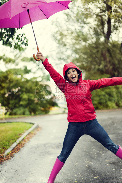 粉红色雨伞下的年轻女子图片