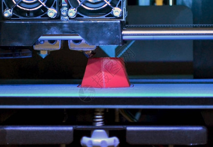 3d打印机在蓝色背景特写上打印红色多面几何形状明亮的对比图像自动三维打印机在实验室背景图片