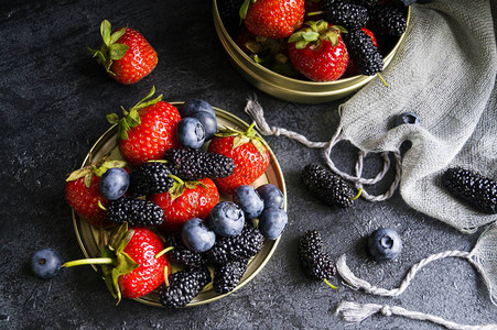 夏季浆果黑色背景中的草莓蓝莓和桑树图片