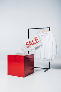 红色立方体衣架上衬衫和销售标志背景图片