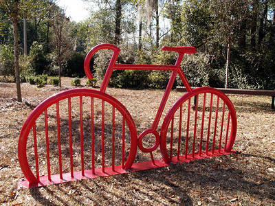 红色的自行车架在一个公园里形状图片