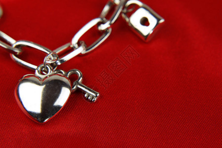 手链上的心和钥匙的特写背景图片