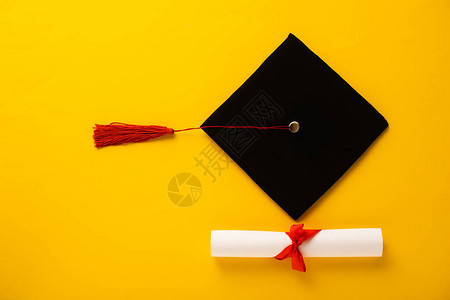 优美的弓首和黄色背景的红船毕业顶礼帽图片