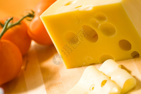 木桌上的美味奶酪背景是番茄图片