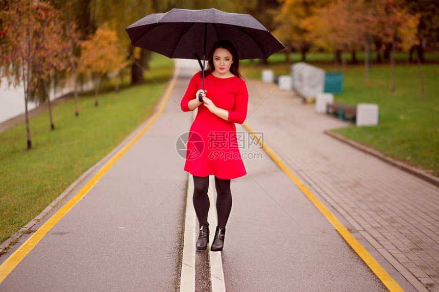 喜悦的女孩在秋天公园的雨伞图片