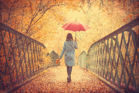 秋天公园带雨伞的年轻美图片
