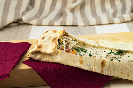 包装在薄的皮卡面包粉碎蔬菜绿菜和切肉香肠中图片