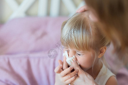 流鼻涕的孩子妈用纸巾帮孩子擤鼻涕背景图片