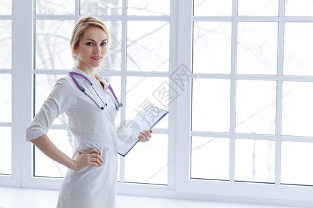 年轻微笑的女医生站在文件纸上背景图片