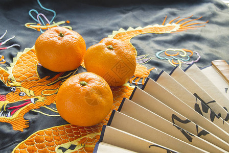 新年橘子和粉丝躺在丝绸织物图片
