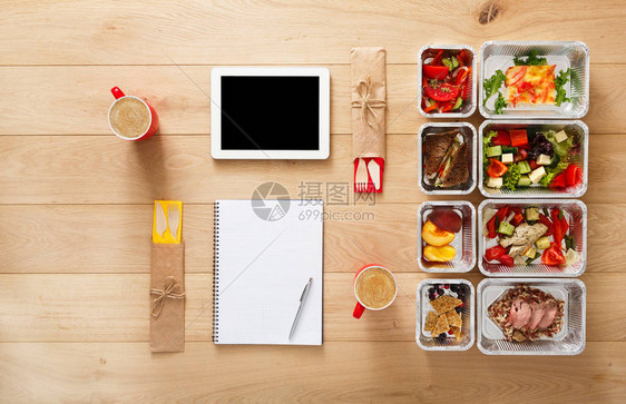 夫妇的健康餐厅食物和饮食计划新鲜的每日膳食交付箔盒咖啡和平板电脑中的健身营养蔬菜肉类和水果顶视图图片