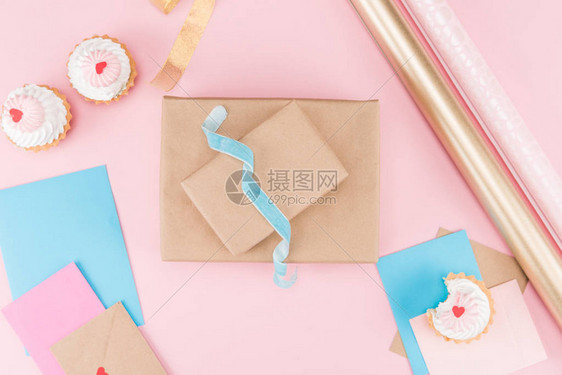 最美味的纸杯蛋糕空白卡丝带包装纸和无包装的粉红色礼品盒图片