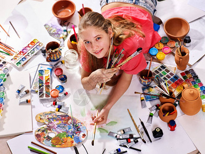 正宗的艺术家儿童女孩在早晨的阳光下用设置的调色板水彩颜料调色板和画笔绘画在地板上的工作室绘画水彩画笔图片