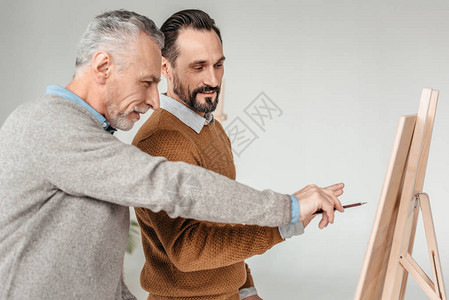 两位男艺术家在艺术课期间观看壁图片