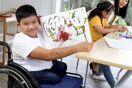 坐在轮椅上的小学生在艺术课图片