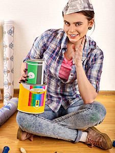 修理家庭妇女拿着油漆滚筒为墙纸报章帽翻新公寓的女孩建筑材料折扣图片