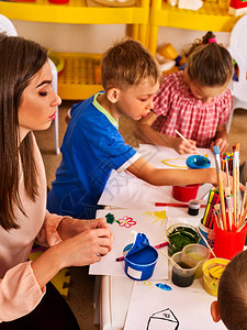 孩子们在儿童俱乐部绘画和绘画小学美术课幼儿园老师帮助小学生孩子男孩在课堂上的桌图片