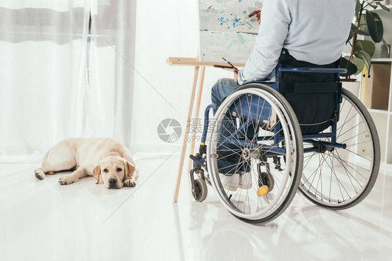 残疾男子躺在地板上时身着轮椅绘画的图片