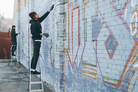 街头艺术家站在梯上在建筑图片
