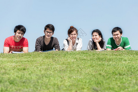 一群朋友在学校的公园里户外学习五名亚洲高中生躺在图片