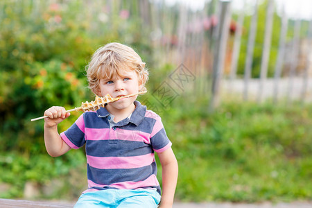 可爱的金发男孩在稻草上吃华夫饼快乐无忧虑的童年有趣的金图片