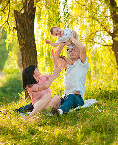 快乐的年轻家庭父亲母亲和小儿子在户外玩得愉快图片