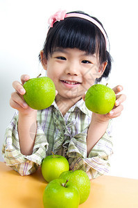 小亚洲儿童在绿苹果上装图片