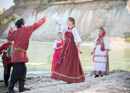 身穿俄罗斯民族服装的年轻人跳舞民间舞蹈做真正的动作演奏图片