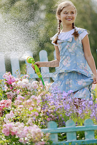 夏天的乐趣浇花可爱的女孩在花园图片