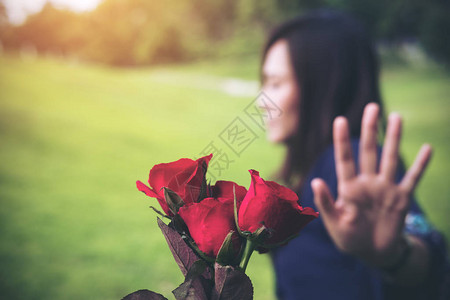 一位亚裔女在情人节拒绝她男友的红玫瑰花朵图片